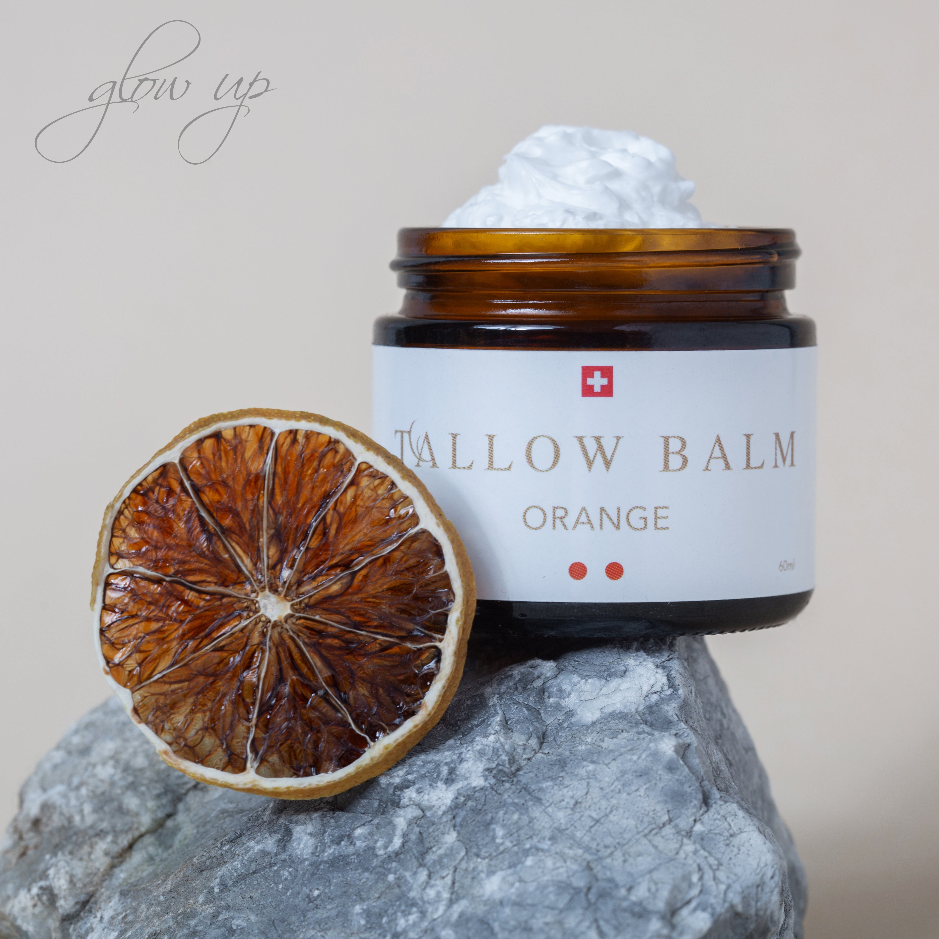 Tallow Balm Orange mit getrockneter Orangenscheibe auf Stein