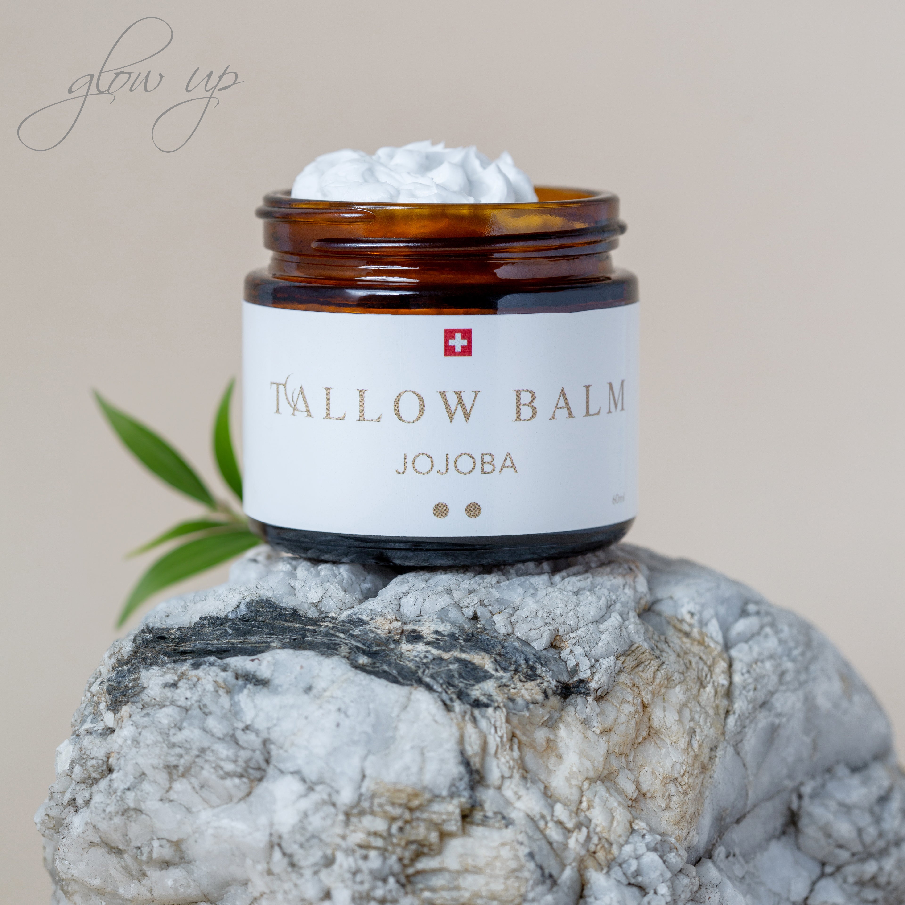 Tallow Balm Jojoba auf Fels und Olivenblatt