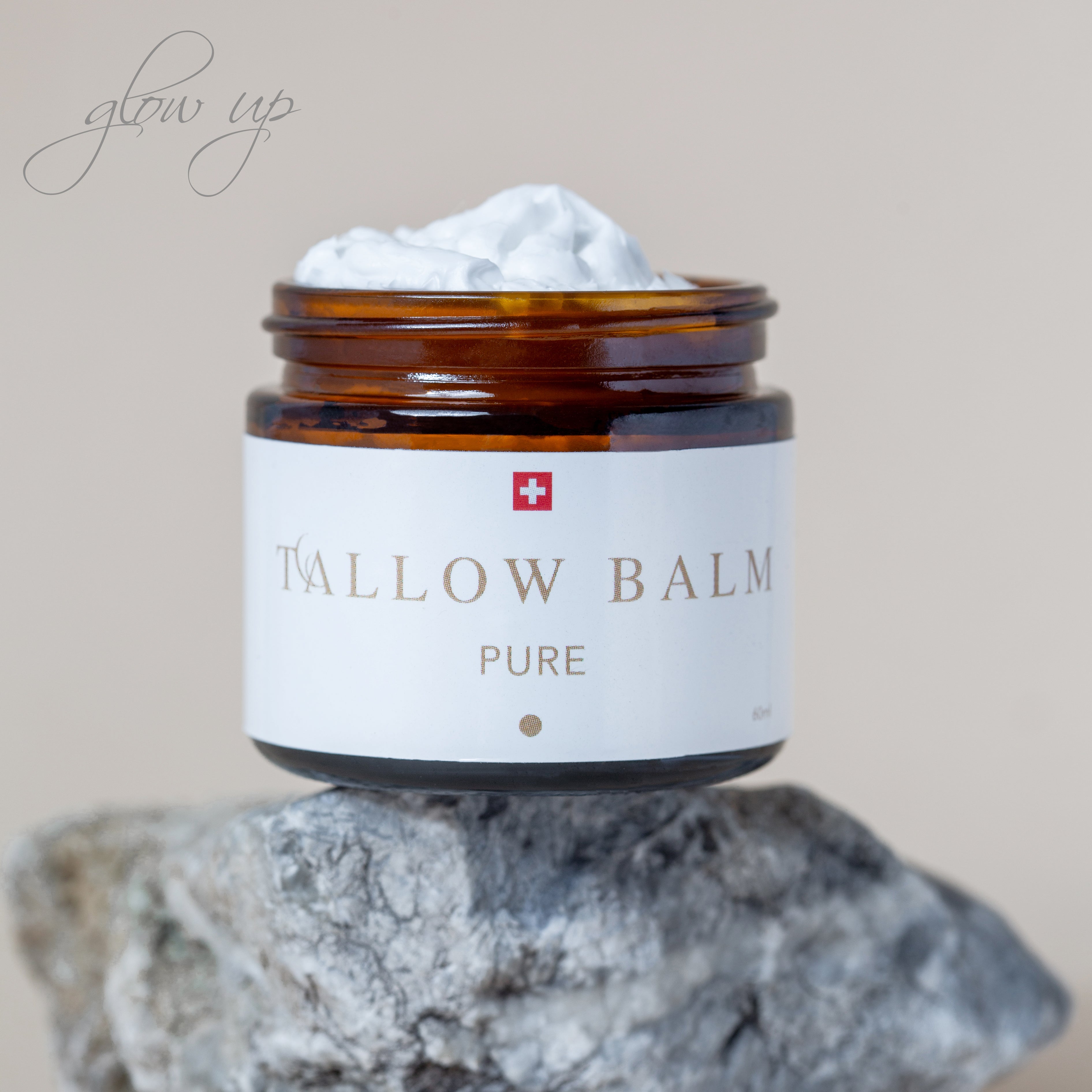 Geöffneter Tallow Balm Pure mit sichtbarer Cremefüllung auf Stein
