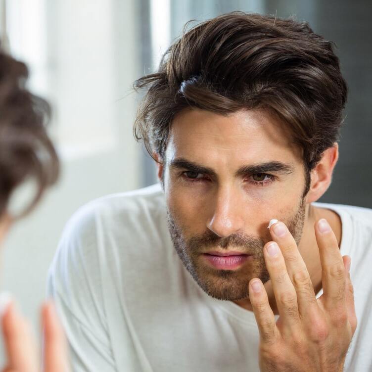 Mann trägt Swiss Tallow Gesichtscreme vor dem Spiegel auf